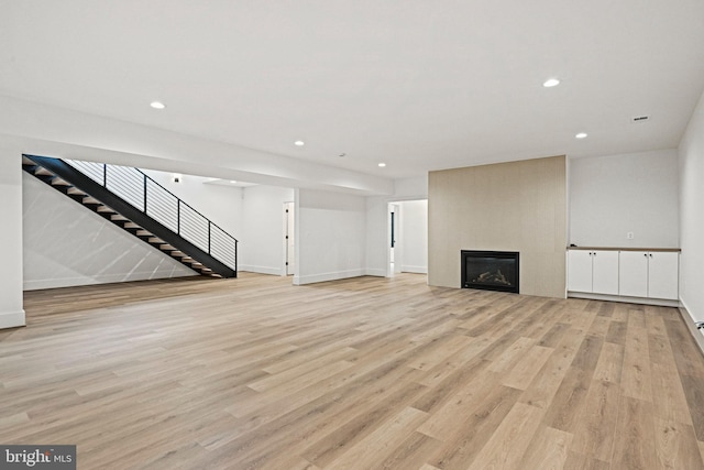 unfurnished living room featuring a fireplace and light hardwood / wood-style floors