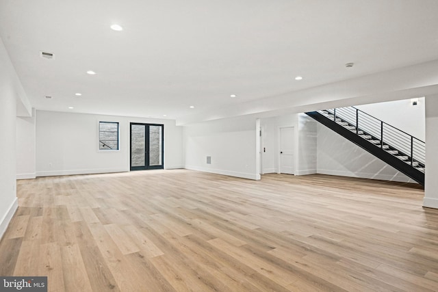 unfurnished living room featuring light hardwood / wood-style floors and french doors