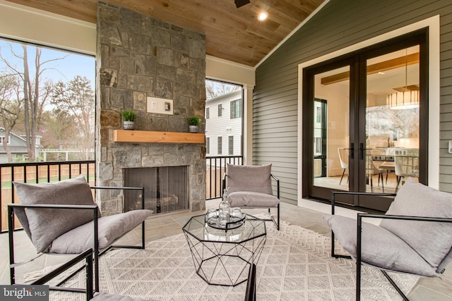 sunroom / solarium with vaulted ceiling, wooden ceiling, and an outdoor stone fireplace