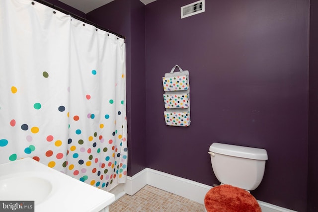 bathroom featuring tile floors and toilet