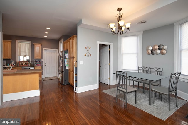 dining room with a chandelier and dark wood-type flooring