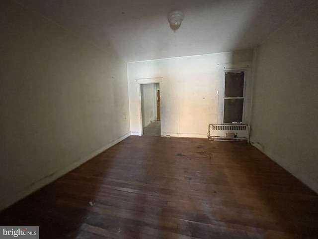 spare room featuring dark hardwood / wood-style floors and radiator heating unit