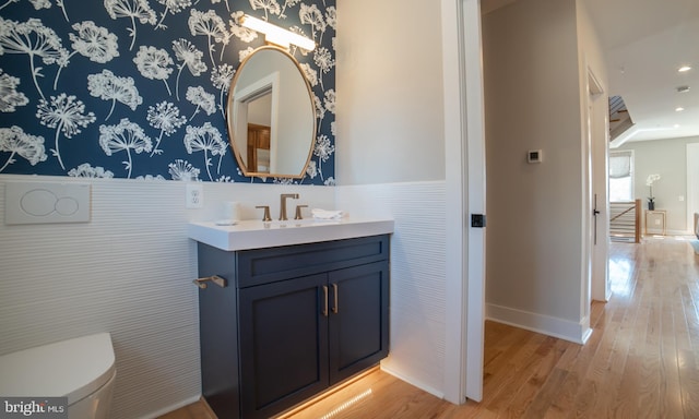 bathroom featuring hardwood / wood-style flooring, toilet, oversized vanity, and backsplash