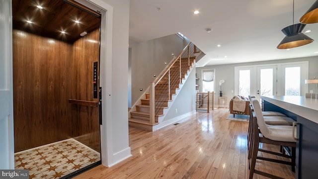 foyer featuring french doors, light tile floors, and elevator