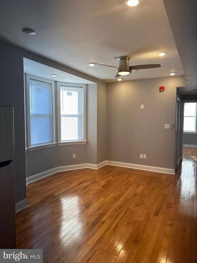 empty room with ceiling fan and dark wood-type flooring