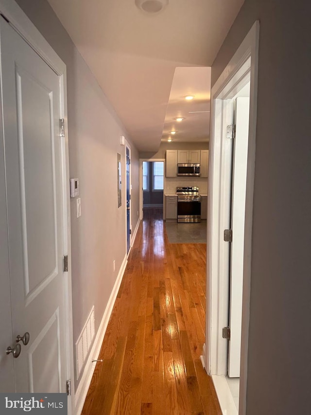 corridor with hardwood / wood-style floors