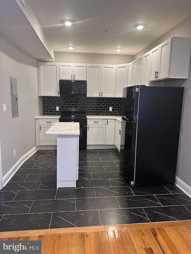 kitchen with tasteful backsplash, a center island, dark tile flooring, black appliances, and white cabinets