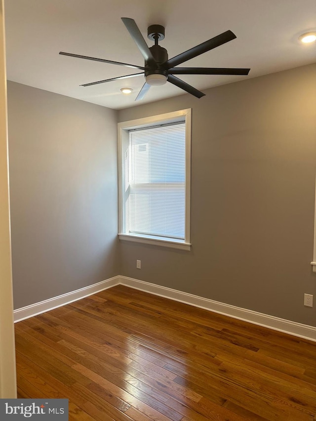 spare room featuring ceiling fan and dark hardwood / wood-style floors