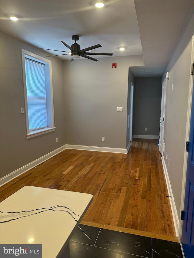 empty room with dark hardwood / wood-style flooring and ceiling fan