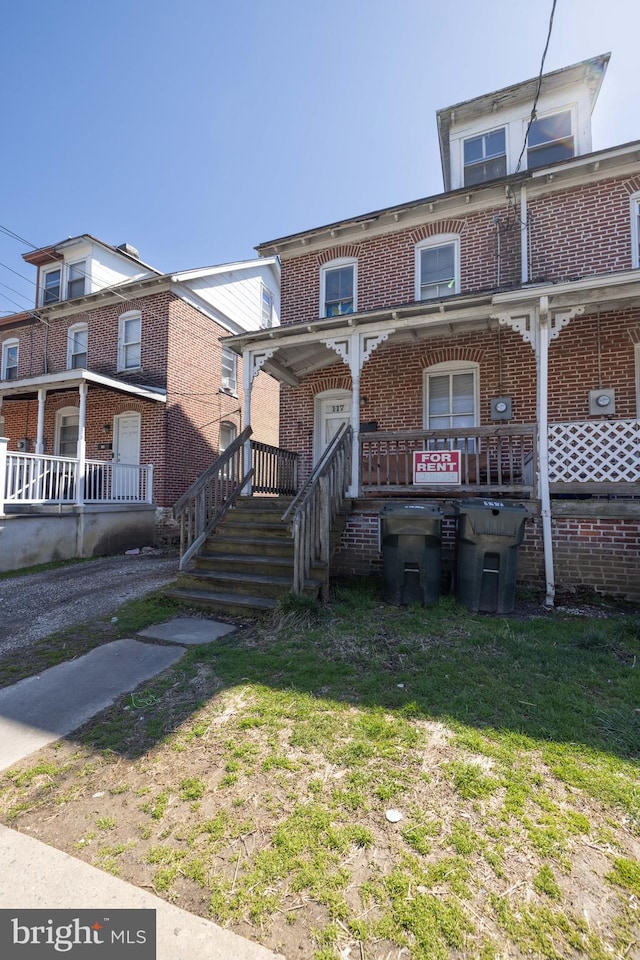 view of front of home with a porch and a front lawn