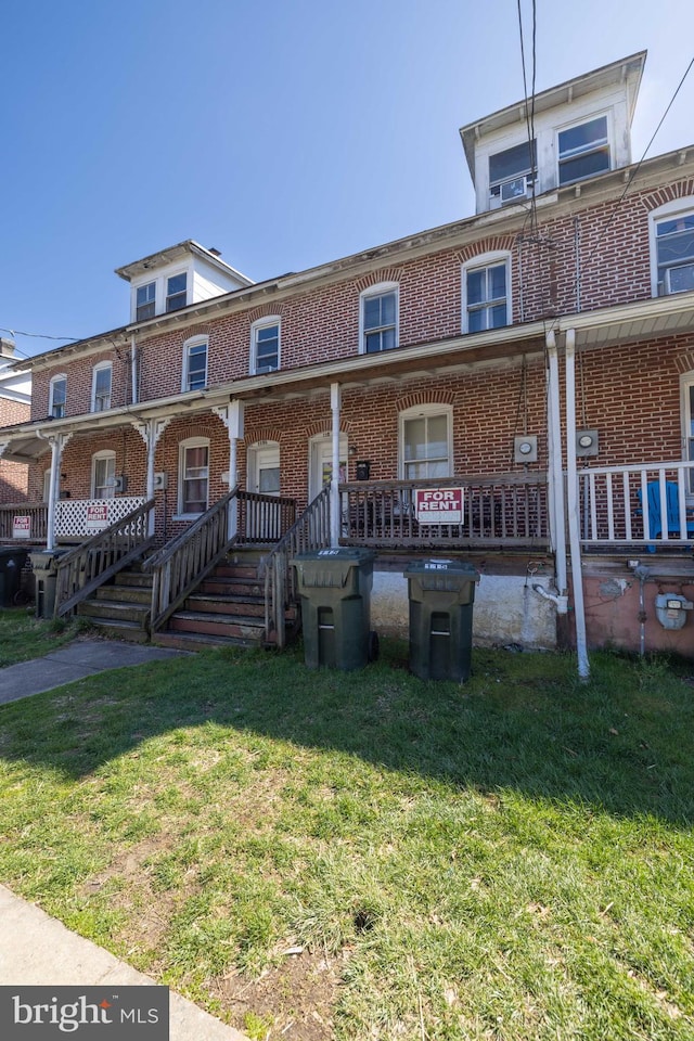 view of front of property with covered porch and a front yard