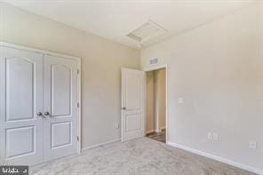 unfurnished bedroom with light colored carpet and a closet