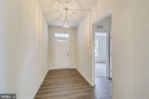 entryway featuring dark hardwood / wood-style floors and a notable chandelier