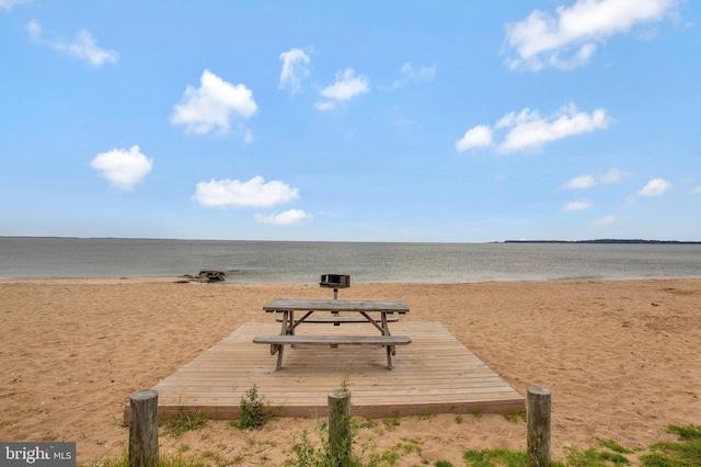 view of property's community with a water view and a beach view