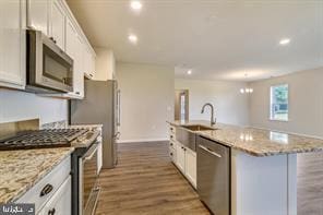 kitchen featuring appliances with stainless steel finishes, sink, a center island with sink, and white cabinets