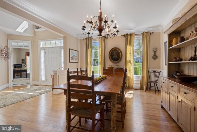 dining space with a notable chandelier, crown molding, and light hardwood / wood-style floors