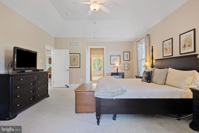 carpeted bedroom featuring connected bathroom, a raised ceiling, and ceiling fan