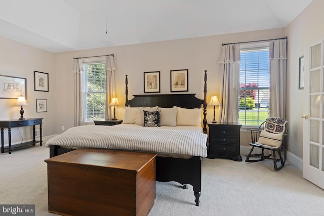 carpeted bedroom with lofted ceiling and multiple windows