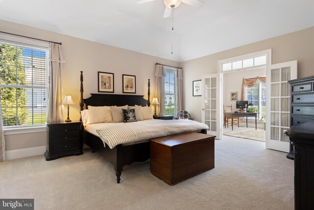 bedroom featuring french doors, light colored carpet, vaulted ceiling, and multiple windows