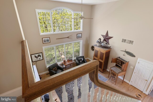 office space featuring a high ceiling, wood-type flooring, and ceiling fan