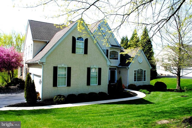 view of front of home with a garage and a front lawn