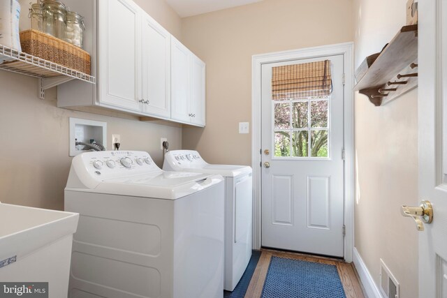 clothes washing area featuring cabinets, separate washer and dryer, sink, and dark wood-type flooring