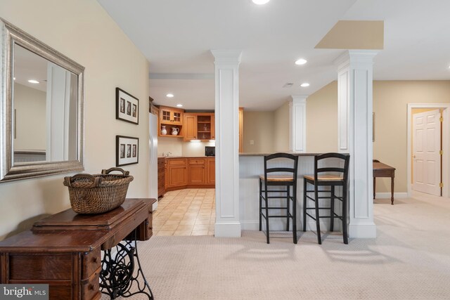 kitchen with ornate columns and light colored carpet