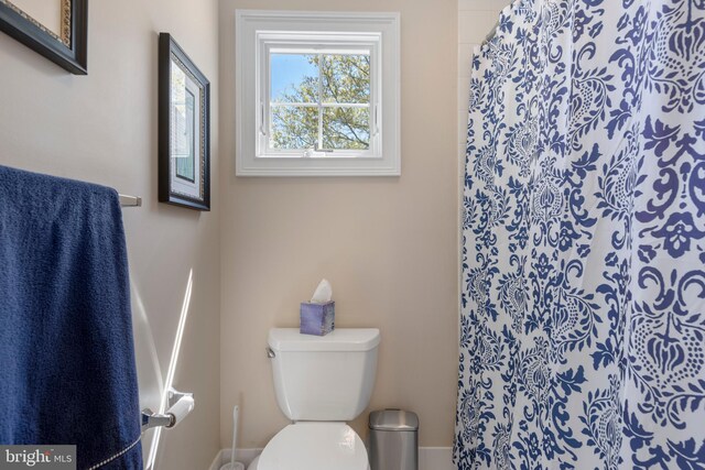 bathroom featuring a shower with curtain and toilet