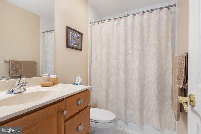 full bathroom with tile patterned flooring, vanity, shower / bath combo with shower curtain, and toilet