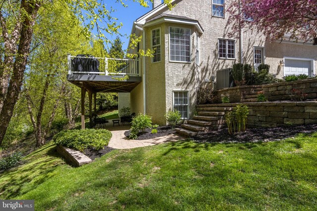 back of house with a balcony, a yard, and a patio area