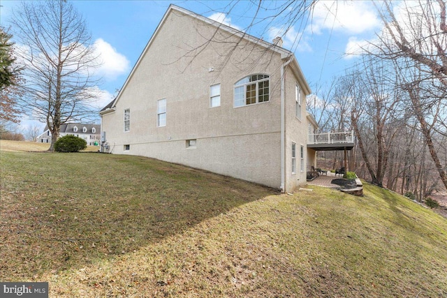 view of property exterior with a patio and a lawn