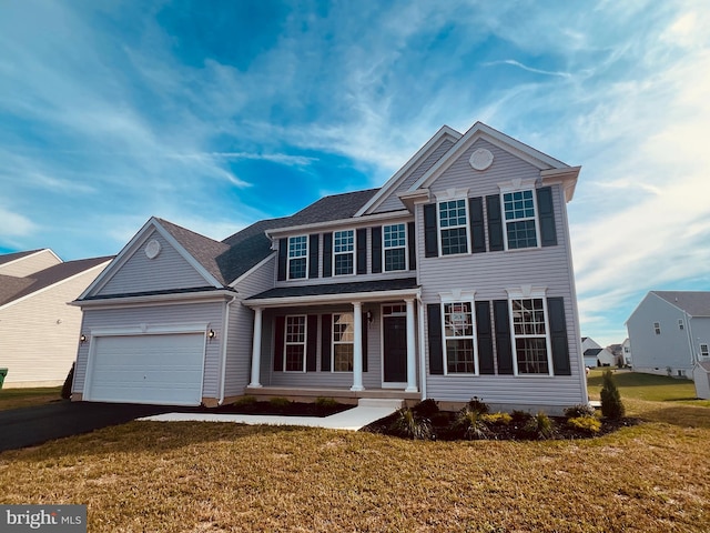 view of front of property featuring a garage, a front yard, and covered porch