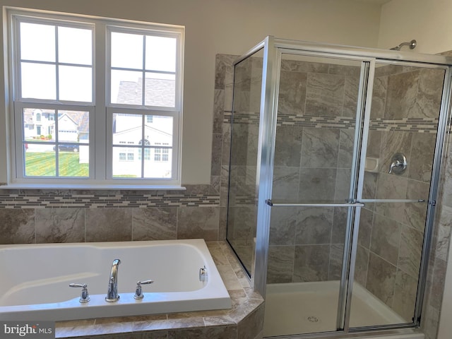 bathroom featuring plus walk in shower and a healthy amount of sunlight