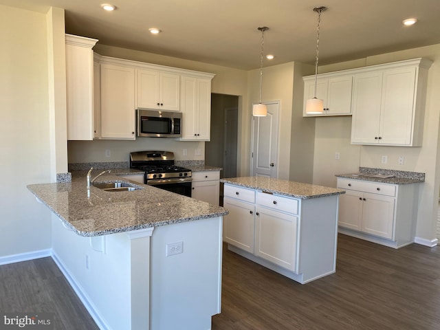 kitchen featuring stainless steel appliances, kitchen peninsula, sink, and white cabinets