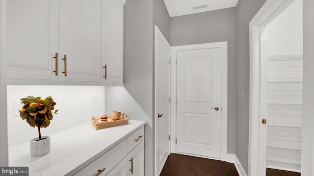 interior space with dark hardwood / wood-style flooring and white cabinetry