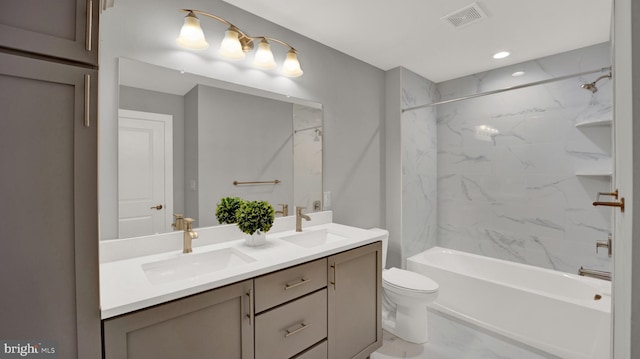 full bathroom featuring tile flooring, double sink vanity, toilet, and tiled shower / bath combo