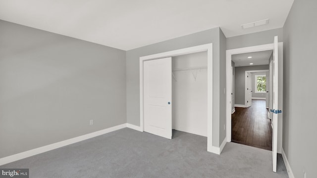 unfurnished bedroom featuring a closet and light carpet