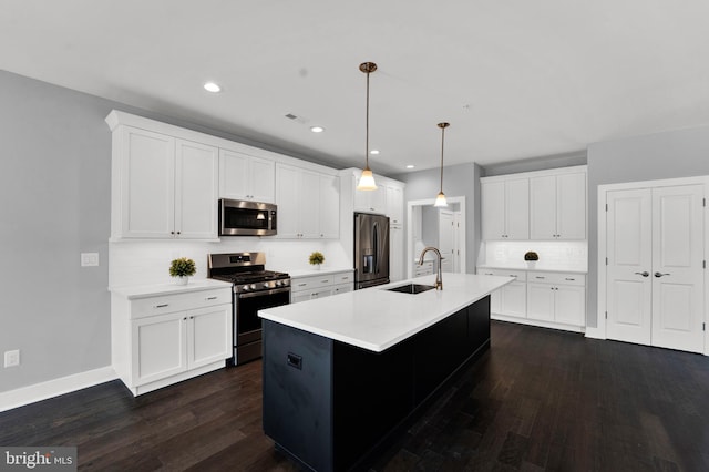 kitchen with hanging light fixtures, stainless steel appliances, dark hardwood / wood-style flooring, sink, and white cabinets