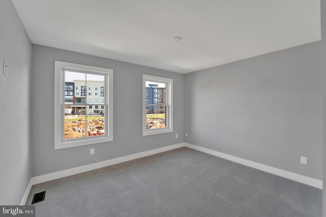 unfurnished room featuring dark carpet