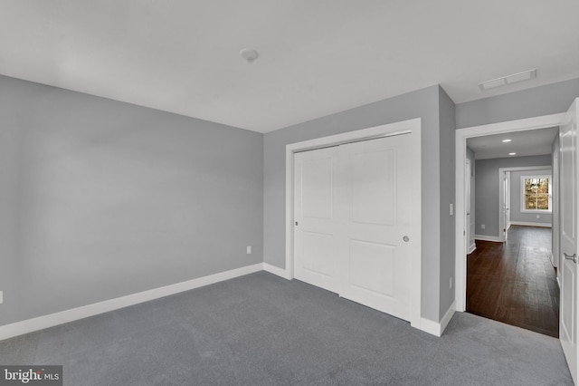 unfurnished bedroom with a closet and dark hardwood / wood-style floors