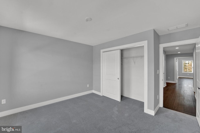 unfurnished bedroom with a closet and dark carpet