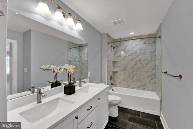 full bathroom featuring tiled shower / bath combo, toilet, tile floors, and double sink vanity