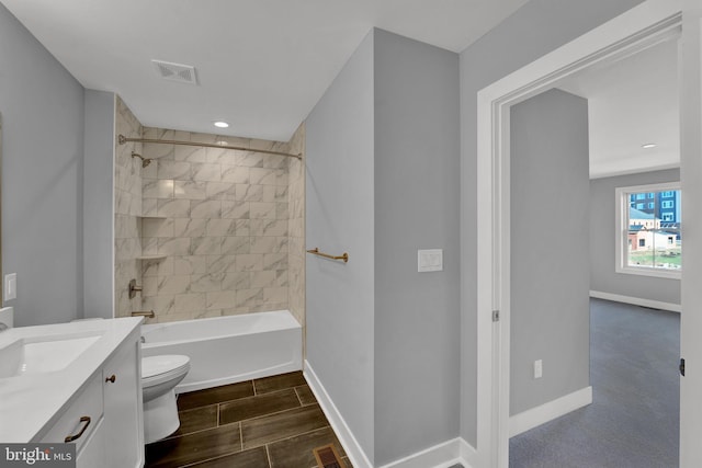 full bathroom featuring tiled shower / bath, toilet, tile flooring, and vanity