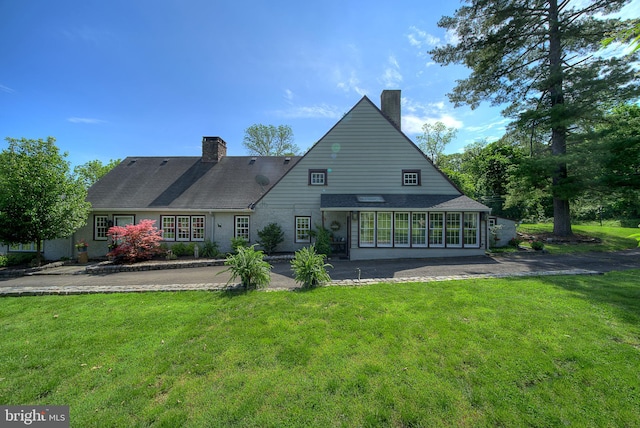 rear view of property with a lawn