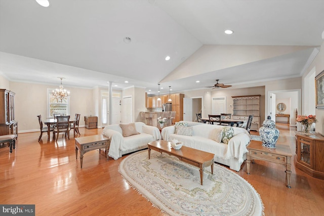 living room with ceiling fan with notable chandelier, light hardwood / wood-style floors, crown molding, and vaulted ceiling