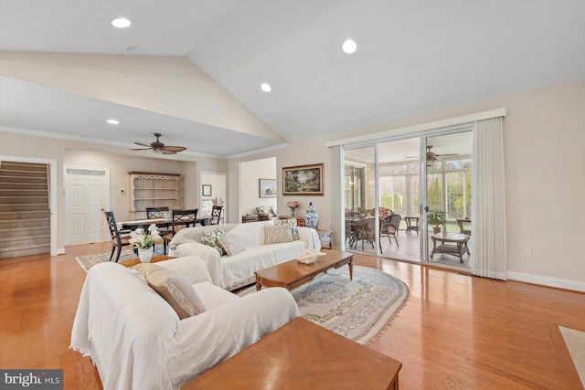 living room featuring ceiling fan, light wood-type flooring, and lofted ceiling