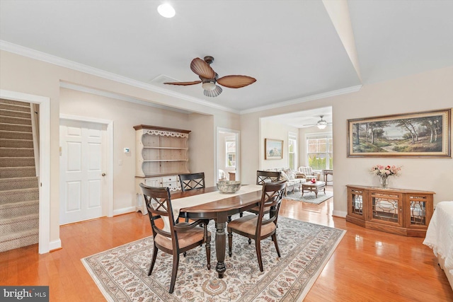 dining area featuring crown molding, ceiling fan, and light hardwood / wood-style floors