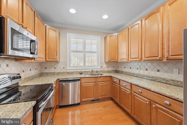 kitchen featuring tasteful backsplash, light stone counters, crown molding, light hardwood / wood-style floors, and appliances with stainless steel finishes