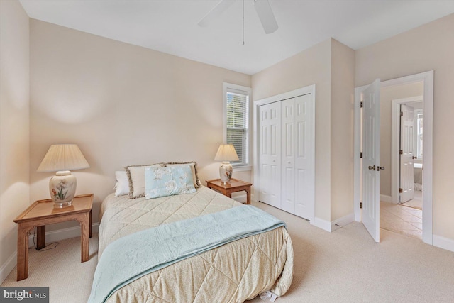 carpeted bedroom with ceiling fan and a closet