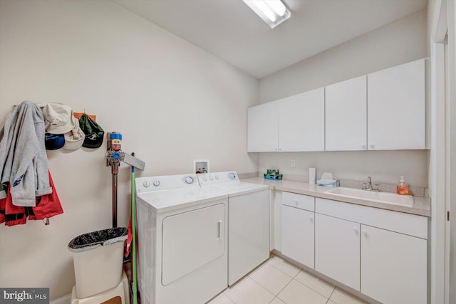 washroom with sink, light tile patterned flooring, cabinets, and independent washer and dryer